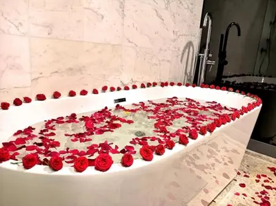a bath tub filled with red roses in a bathroom at The Face Platinum Suites KLCC in Kuala Lumpur