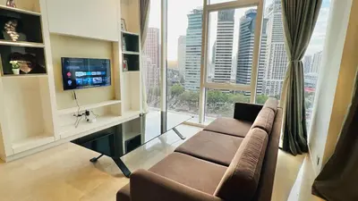 a living room with a couch and a desk with a television at The Face Platinum Suites KLCC in Kuala Lumpur