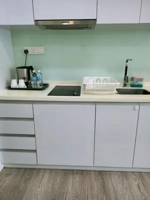 a kitchen with white cabinets and a sink at Oneiro One Bukit Ceylon in Kuala Lumpur