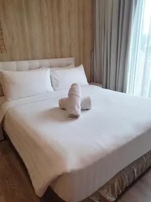 a white bed with towels on top of it at Oneiro One Bukit Ceylon in Kuala Lumpur