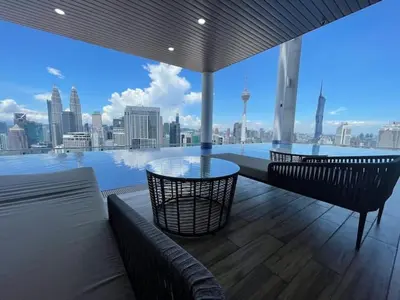 a balcony with a glass table and a view of the city at Colony @ Kampung Baru by Plush in Kuala Lumpur
