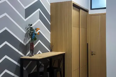 a room with a table with a vase of flowers on a wall at Colony @ Kampung Baru by Plush in Kuala Lumpur