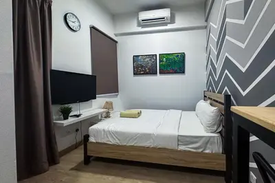 a small bedroom with a bed and a tv at Colony @ Kampung Baru by Plush in Kuala Lumpur
