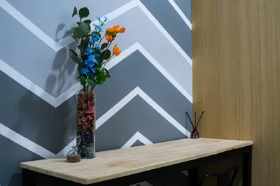 a vase with flowers on top of a table at Colony @ Kampung Baru by Plush in Kuala Lumpur