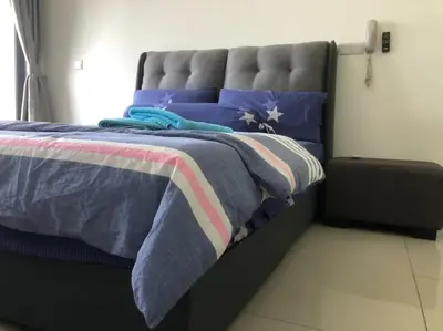 a bedroom with a bed with blue and purple pillows at Happy Continew Residence 2 Bedrooms - TRX KL in Kuala Lumpur