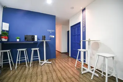 a room with stools and a blue wall at Meta Hotel in Kuala Lumpur