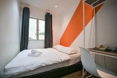 a small bedroom with a bed and a desk at Meta Hotel in Kuala Lumpur