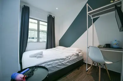 a small bedroom with a bed and a desk at Meta Hotel in Kuala Lumpur