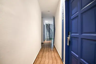 a hallway with a blue door and a wooden floor at Meta Hotel in Kuala Lumpur