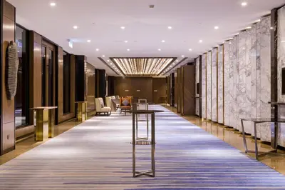a corridor of a hotel lobby with a table and chairs at M Resort & Hotel Kuala Lumpur in Kuala Lumpur