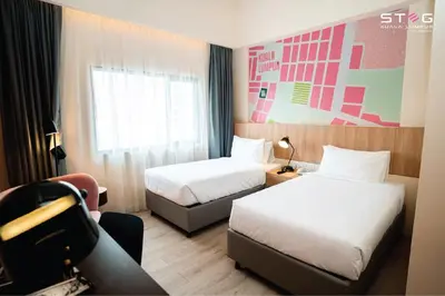 a hotel room with two beds and a window at STEG Kuala Lumpur in Kuala Lumpur