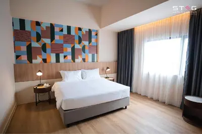 a bedroom with a white bed and a large window at STEG Kuala Lumpur in Kuala Lumpur