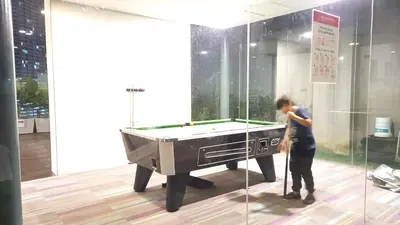 a man standing next to a pool table in a room at CUSHY APARTMENT at KLCC in Kuala Lumpur