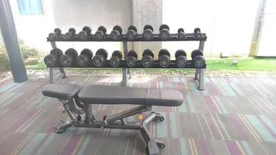 a bench with lots of dumbbells in a gym at CUSHY APARTMENT at KLCC in Kuala Lumpur