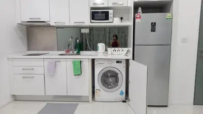 a kitchen with a washing machine and a refrigerator at CUSHY APARTMENT at KLCC in Kuala Lumpur