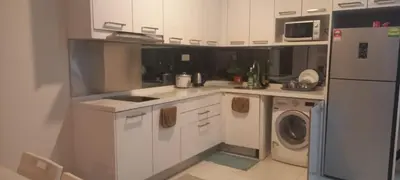 a kitchen with white cabinets and a washer and dryer at CUSHY APARTMENT at KLCC in Kuala Lumpur