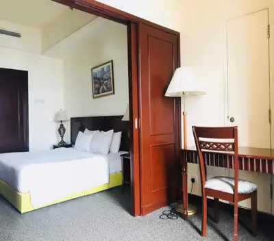 a bedroom with a bed and a chair and a door at KL BERJAYA TIMES SQUARE SERVICe APARTMENT in Kuala Lumpur