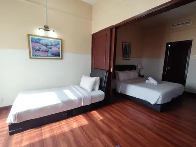 two beds in a room with wooden floors at KL BERJAYA TIMES SQUARE SERVICe APARTMENT in Kuala Lumpur