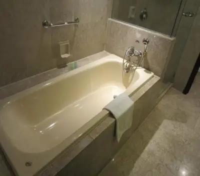 a bathroom with a white bath tub with a towel on it at KL BERJAYA TIMES SQUARE SERVICe APARTMENT in Kuala Lumpur