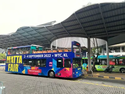 a double decker bus parked at a bus station at Opus Residences Merdeka Tower 118 View in Kuala Lumpur
