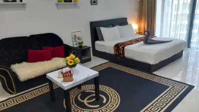a hotel room with two beds and a couch at Summer Suites Klcc by Malenehom in Kuala Lumpur