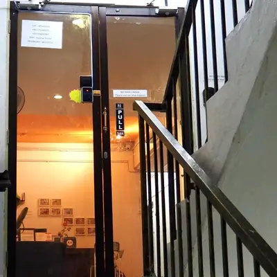 a door with a sign on it next to a staircase at Bestow Capsule Hostel in Kuala Lumpur