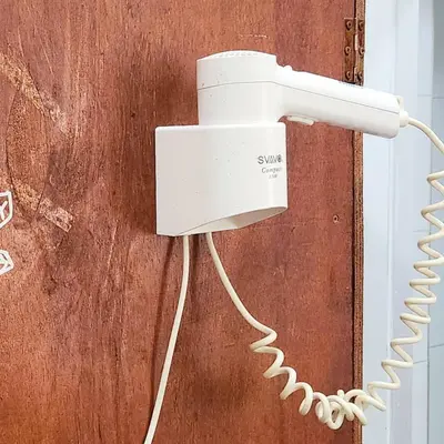 a white phone is attached to a wall at Bestow Capsule Hostel in Kuala Lumpur