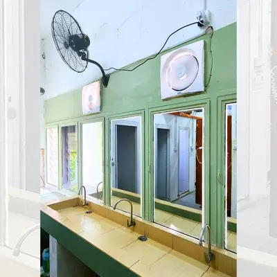 a bathroom with a green wall with a mirror at Bestow Capsule Hostel in Kuala Lumpur