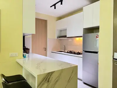 a kitchen with white cabinets and a marble counter top at Legasi Kampung Baru KL Homestay in Kuala Lumpur