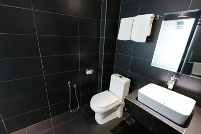 a bathroom with a toilet and a sink and a mirror at Hotel 99 Kuala Lumpur City in Kuala Lumpur