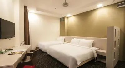 a hotel room with two beds and a desk at Palette KL Sentral Station Formerly Scott Hotel in Kuala Lumpur
