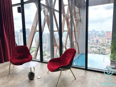 two red chairs in a room with a large window at Scarletz Suites KLCC by MyKey in Kuala Lumpur
