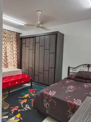 a bedroom with a bed and a red bedspread at Homestay D'Zara in Kuala Lumpur