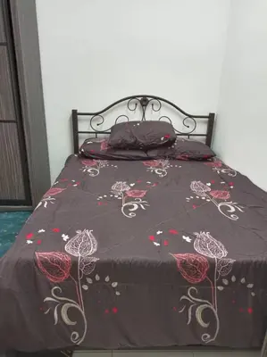 a bed with a black blanket with flowers on it at Homestay D'Zara in Kuala Lumpur