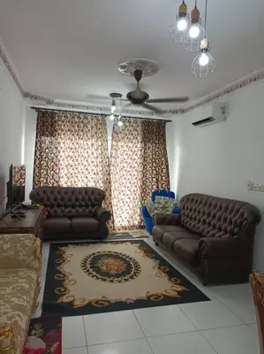 a living room with two couches and a rug at Homestay D'Zara in Kuala Lumpur