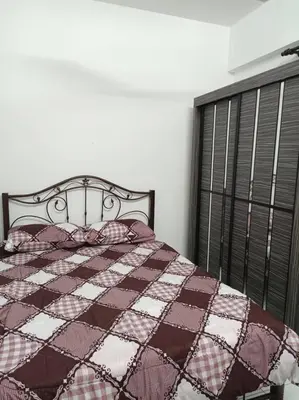 a bedroom with a bed with a quilt and a window at Homestay D'Zara in Kuala Lumpur