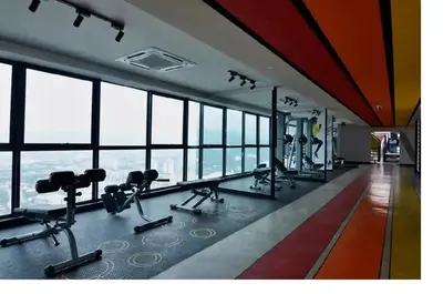 a gym with treadmills and machines in a building with windows at Stylish & Cozy 2BR Apt at Arte Plus, FREE Parking in Kuala Lumpur