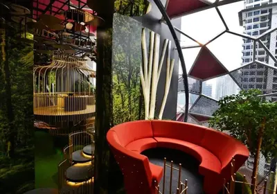 a red bench in a room with a bird cage at Stylish & Cozy 2BR Apt at Arte Plus, FREE Parking in Kuala Lumpur