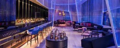 a room with a bar with tables and chairs at Tropicana The Residences KLCC By Luxury Suites in Kuala Lumpur
