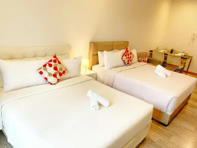 a hotel room with two beds and a couch at Lila Suites One Bukit Ceylon in Kuala Lumpur