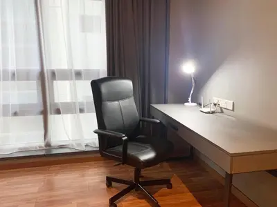 a black chair sitting at a desk with a lamp at The Infinite - Bangsar Trade Centre in Kuala Lumpur