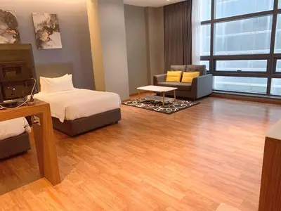 a bedroom with a bed and a couch and a chair at The Infinite - Bangsar Trade Centre in Kuala Lumpur