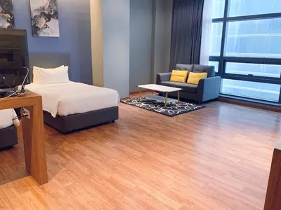 a bedroom with a bed and a couch and a tv at The Infinite - Bangsar Trade Centre in Kuala Lumpur