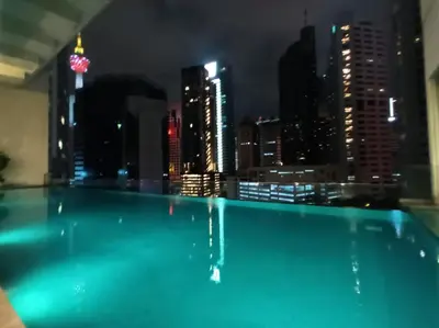 a swimming pool with a city skyline at night at City Home Suites Kuala Lumpur City Centre in Kuala Lumpur
