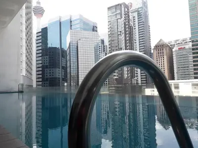 a pool with a view of a city with tall buildings at City Home Suites Kuala Lumpur City Centre in Kuala Lumpur