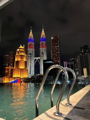 a view of the city at night from a pool at Legasi Kampung Bharu by Tulip in Kuala Lumpur