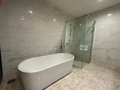 a white bath tub in a bathroom with a glass shower at Platinum KLCC By Rainbow Suites in Kuala Lumpur
