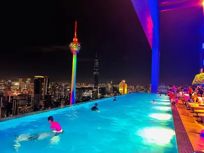 a group of people in a infinity pool with a city skyline at Platinum KLCC By Rainbow Suites in Kuala Lumpur