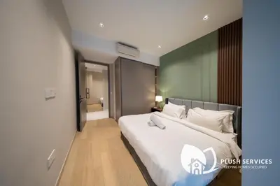 a bedroom with a large white bed in a room at Eaton Residences KLCC by Plush in Kuala Lumpur