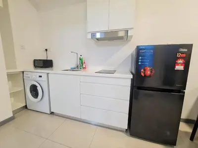 a kitchen with a refrigerator and a washing machine at Bangsar South Apartment by Sarah's Lodge @ SouthLink Lifestyle Apartment in Kuala Lumpur